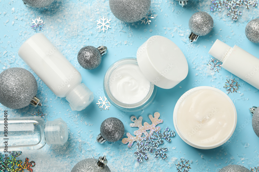 Concept of face care with cosmetics on background with decorative snow Concept of face care with cosmetics on background with decorative snow