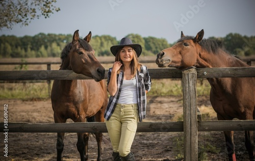 American woman on a horse farm. Portrait of girl in cowboy hat with a  horses. Hippotherapy at nature © T.Den_Team