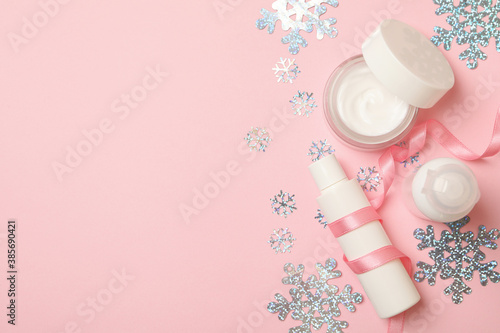 Cosmetics and snowflakes on pink background, space for text