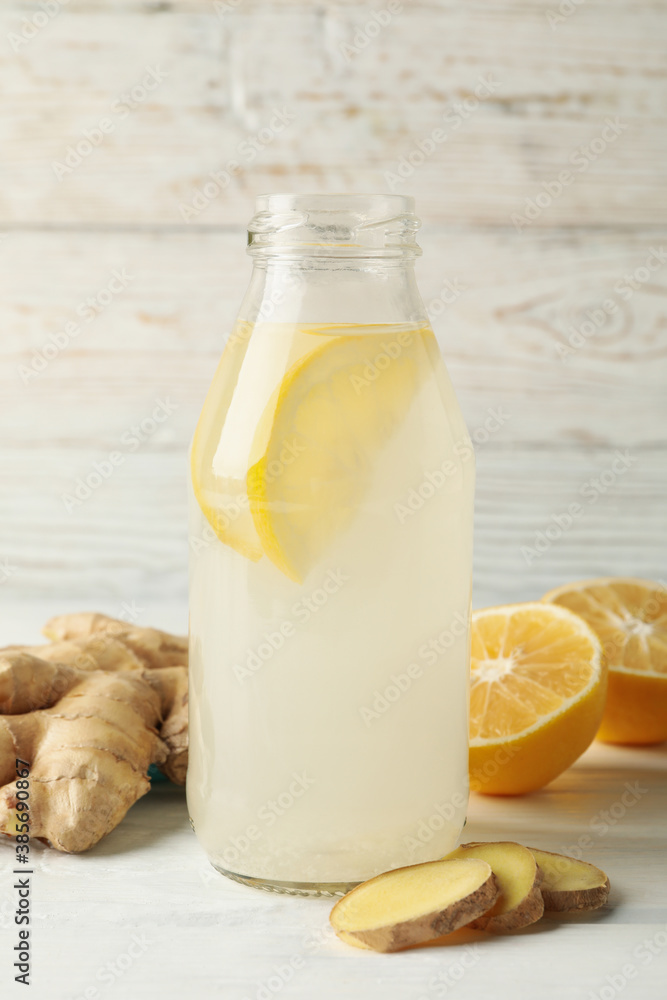 Bottle of ginger lemon water on white wooden background Bottle of ginger lemon water on white wooden background