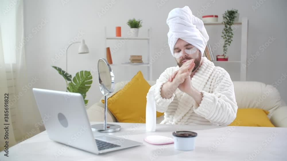 Skin treatment and selfcare concept. Smiling young man applying eye mask at home