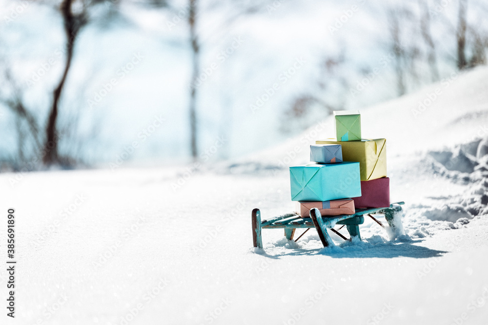 Colorful presents on a wooden sledge standing in the snow, concept christmas and winter