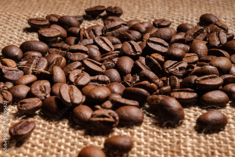 Coffee beans are scattered on the cloth on the table. Coffee beans are scattered on the cloth on the table.