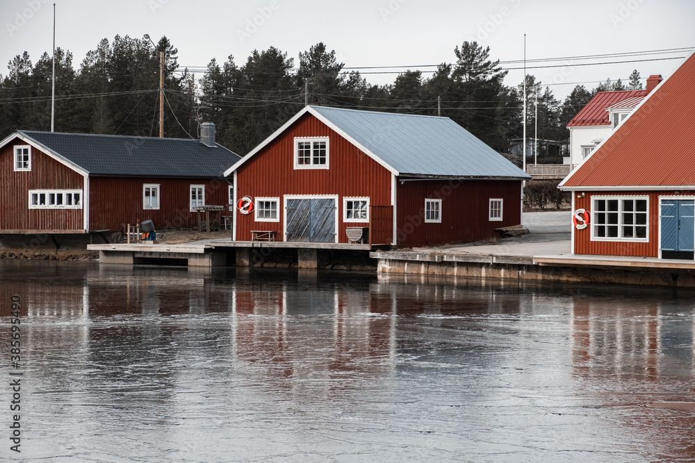 Red boat house in Sweden with reflection on the ice Red boat house in Sweden with reflection on the ice