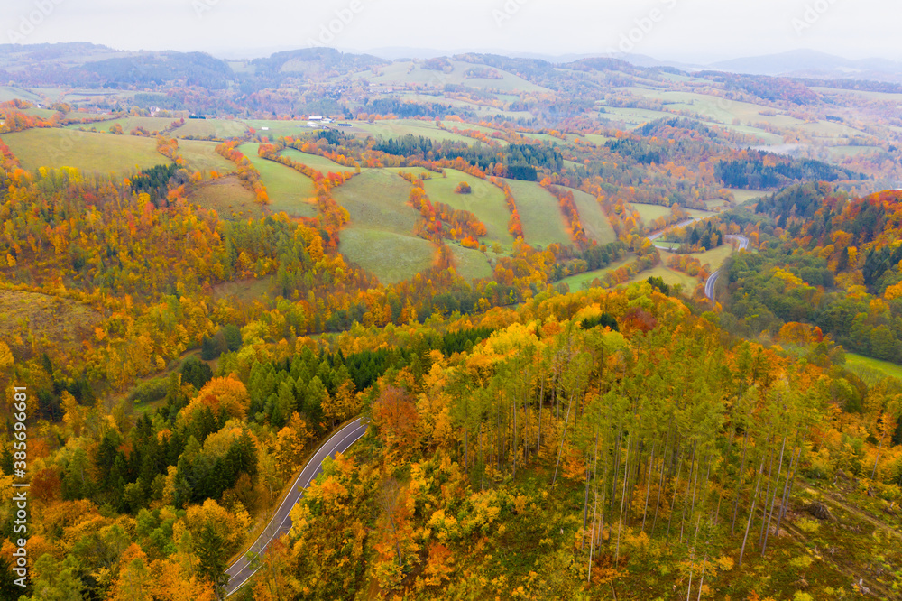 Picturesque autumn landscape with road between the hills. Czech Republic