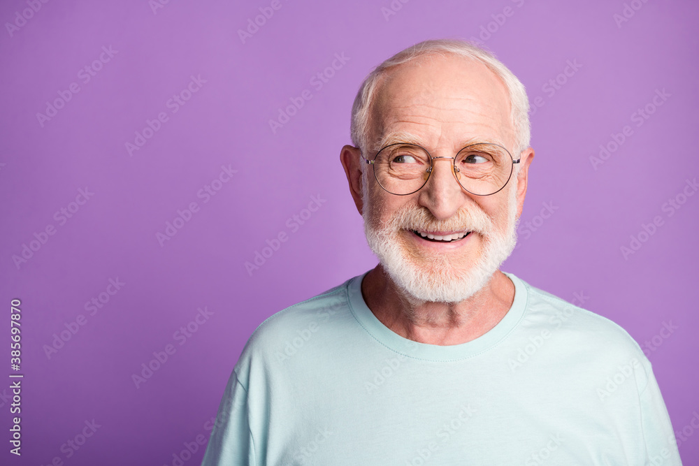 Portrait of beard old man wear light blue t-shirt spectacles look empty space isolated on violet color background Portrait of beard old man wear light blue t-shirt spectacles look empty space isolated on violet color background