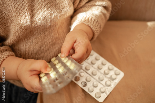 The child took out pills, the girl is playing with medical medicine, a one-year-old child can eat pills and not wake up, poison. Danger in the house, medicines are dangerous for young children.