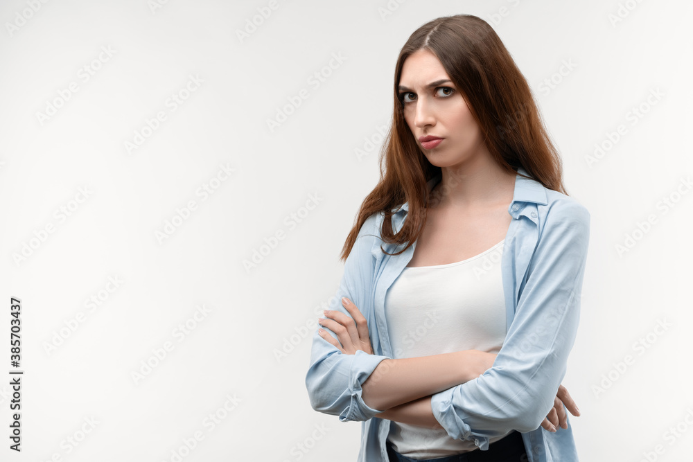 Portrait of beautiful brunette girl looking at camera suspiciously. Studio shot, white background. Copy space Portrait of beautiful brunette girl looking at camera suspiciously. Studio shot, white background. Copy space