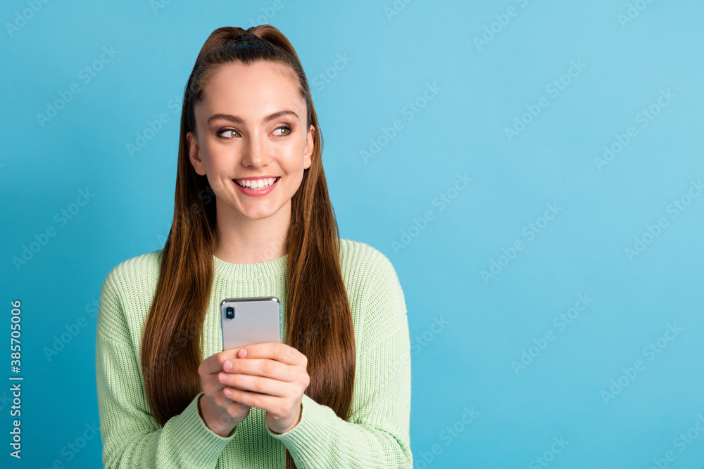Close-up portrait of her she nice attractive lovely cheerful cheery brown-haired girl using device looking aside copy empty space advert isolated bright vivid shine vibrant blue color background Close-up portrait of her she nice attractive lovely cheerful cheery brown-haired girl using device looking aside copy empty space advert isolated bright vivid shine vibrant blue color background