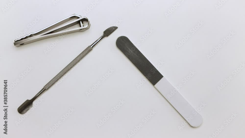 Scissors, files, knife, scraper are removed from the table. We do the manicure ourselves. Self-care nails. Isolated video on a white background. Close-up. Warm, soft light. UHD Scissors, files, knife, scraper are removed from the table. We do the manicure ourselves. Self-care nails. Isolated video on a white background. Close-up. Warm, soft light. UHD