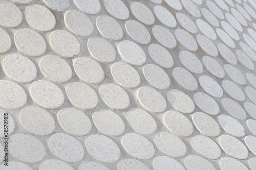 Close-up of abstract geometric white stone slab pattern on a sunny day. Side view, focus on the front. High resolution full frame textured background.