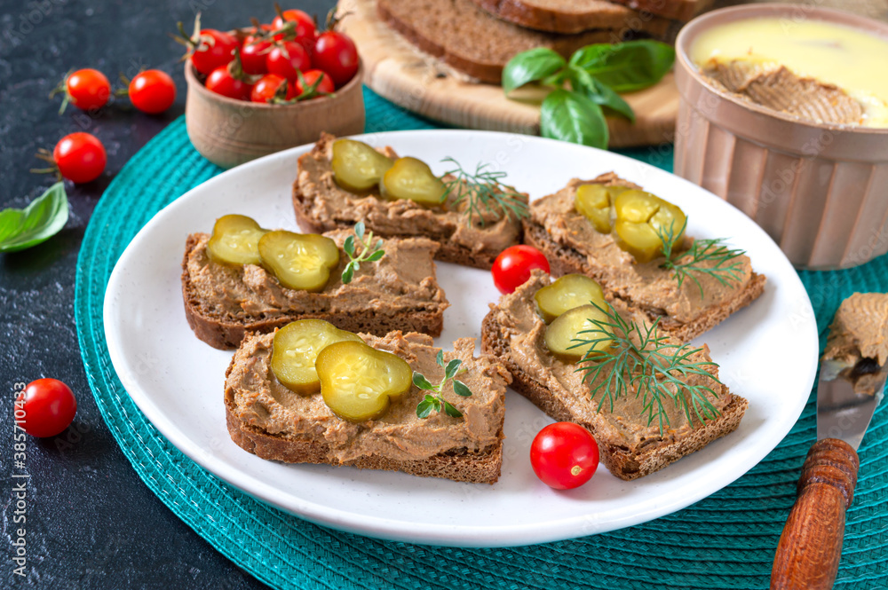 Canapes with chicken liver pate and pickled cucumbers on rye bread. Tasty and healthy appetizer