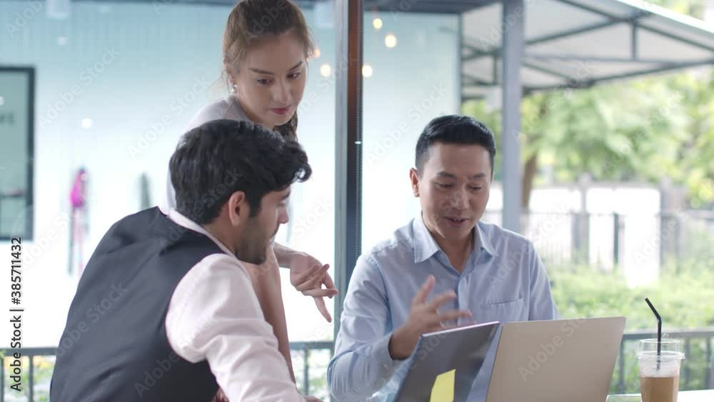 Three asian and caucasian Businesspeople Working discuss finding new strategy solution together with Laptop In cafe Three asian and caucasian Businesspeople Working discuss finding new strategy solution together with Laptop In cafe
