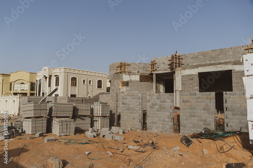 Construction site in the United Arab Emirates or similar concept with concrete shell and bricks in sand. Industrial concept.