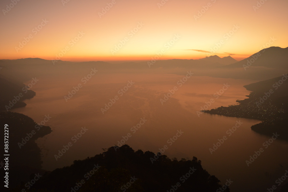 Fototapeta premium Sunrise over the volcanoes of Lake Atitlan in Guatemala, Central America