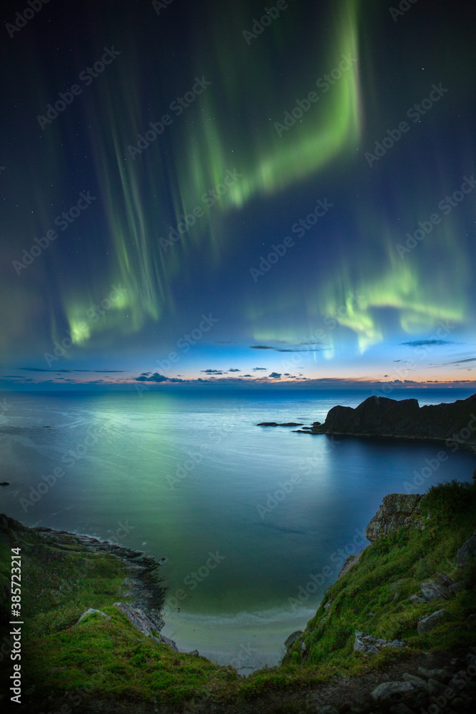 Beautiful night sky with Aurora Borealis aka northern lights in the fjords in Norway.
