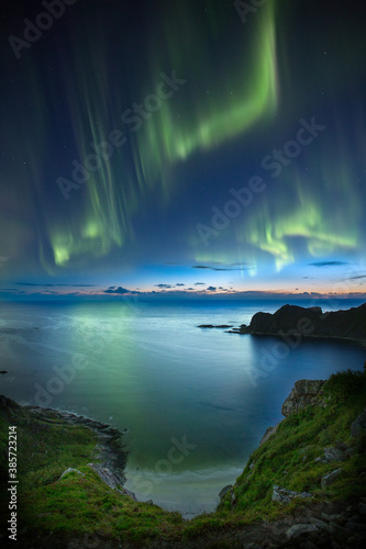 Beautiful night sky with Aurora Borealis aka northern lights in the fjords in Norway. © finnghal