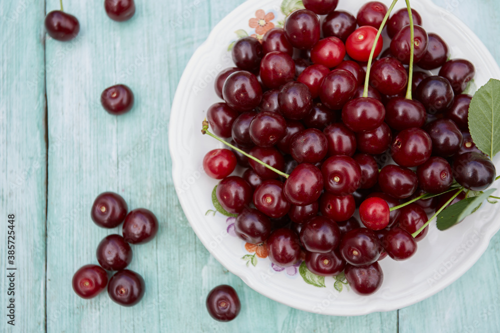 fresh cherries on turquoise wooden surface fresh cherries on turquoise wooden surface