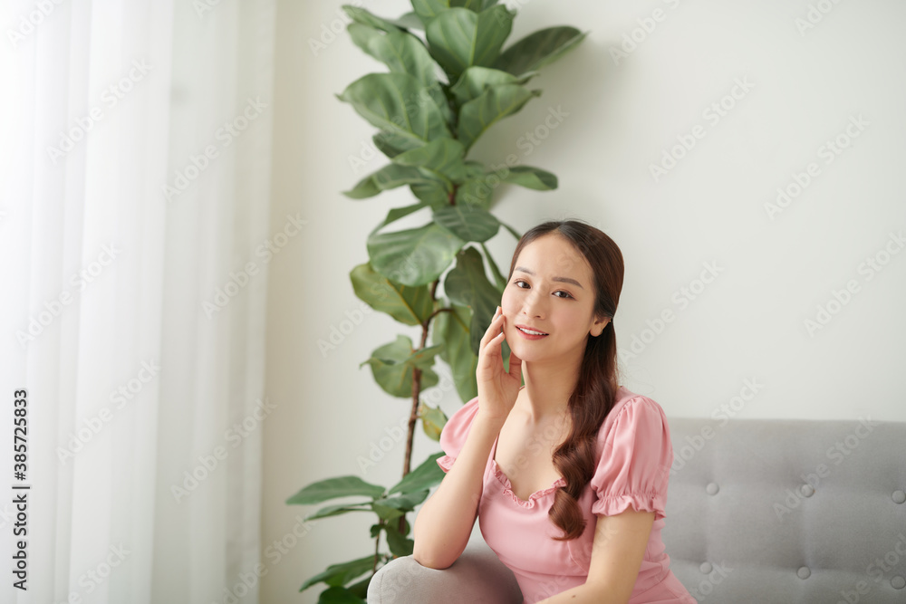 Beautiful Asian woman relaxing at home on couch, enjoying free time. Beautiful Asian woman relaxing at home on couch, enjoying free time.