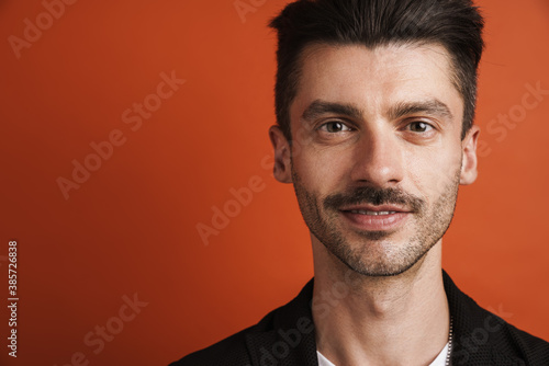 Photo of joyful handsome man smiling and looking at camera