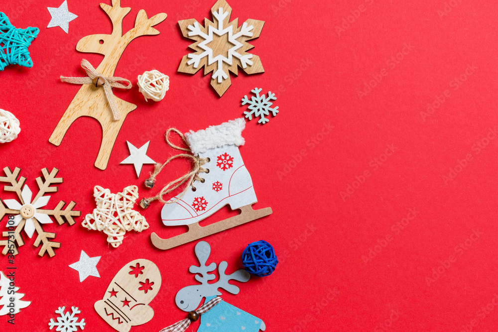 Naklejka premium Top view of holiday toys and decorations on red Christmas background. New Year time concept with copy space