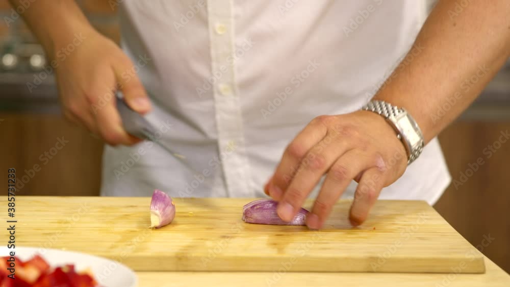 amateur chef cuts onions on wooden chopping board in home kitchen close up. man in kitchen cooks culinary surprise for his wife. Vegetarian, vegan cuisine concept. Beginner Cook's Blog amateur chef cuts onions on wooden chopping board in home kitchen close up. man in kitchen cooks culinary surprise for his wife. Vegetarian, vegan cuisine concept. Beginner Cook's Blog