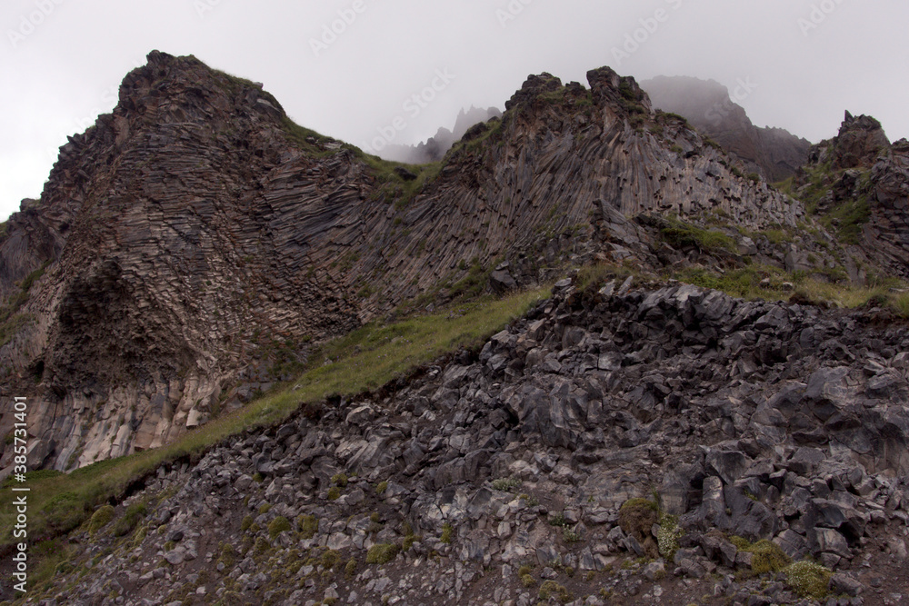 Peaks and slopes of mountains in foggy weather. Elbrus region near the village of Terskol. Caucasus, Russia.