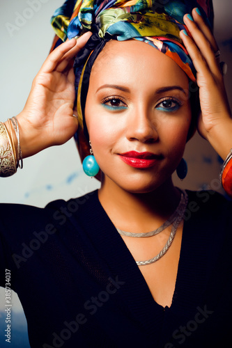 beauty bright african woman with creative make up, shawl on head like cubian closeup smiling photo