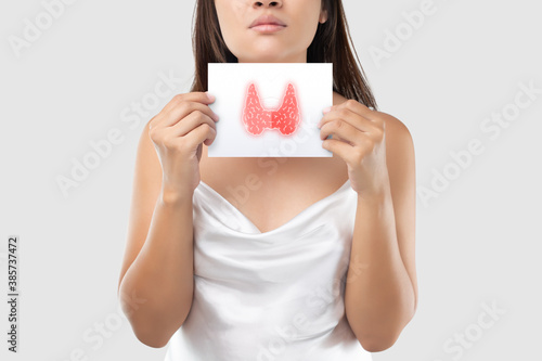 Illustration of the thyroid in the white paper is on the woman's neck. Female thyroid gland control. Sore throat of a people against a light gray background photo