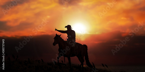 The silhouette of cowboy on horse with evening sunset landscape.