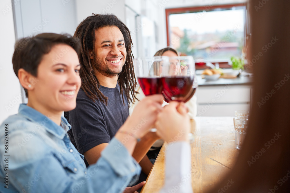 Group of friends at home toasting with glass of red wine Group of friends at home toasting with glass of red wine