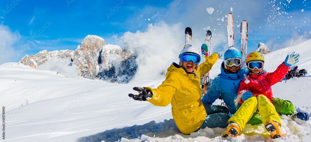 Skiing family enjoying winter vacation on snow in sunny cold day in mountains and fun. San Martino di Castrozza, Italy. - obrazy, fototapety, plakaty 