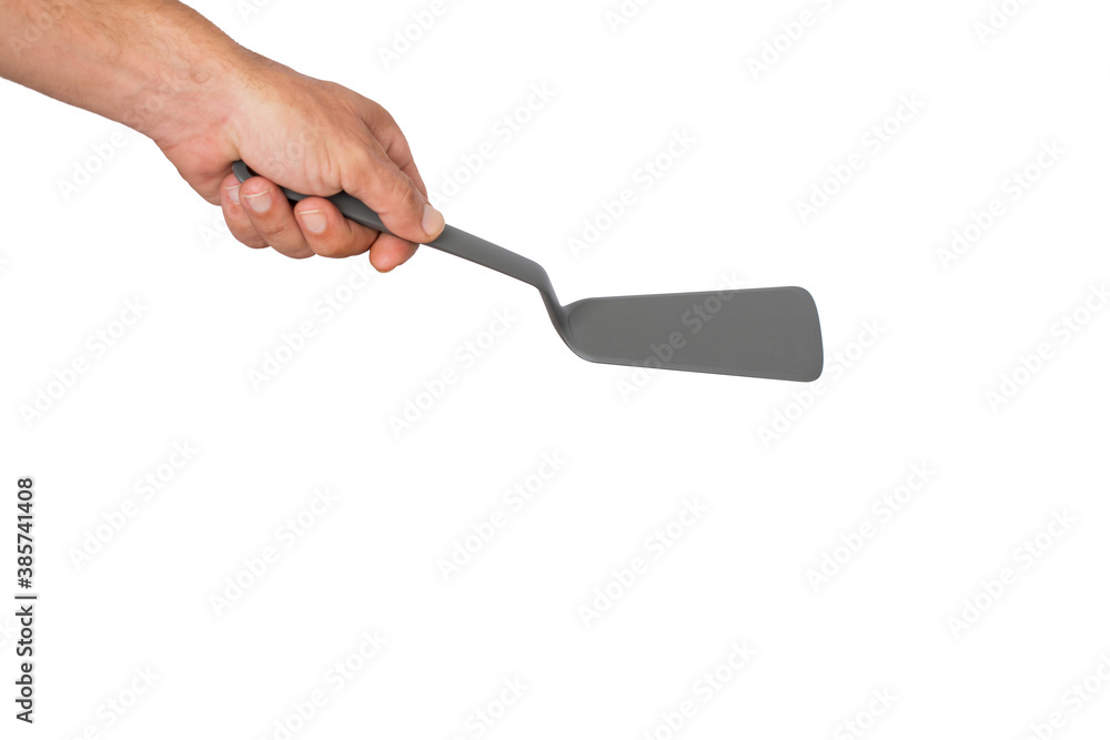 A man's hand holding a spatula for frying, kitchen utensils. Good Isolated on white background. It`s blank for copy, text or your words or sent. A man's hand holding a spatula for frying, kitchen utensils. Good Isolated on white background. It`s blank for copy, text or your words or sent.