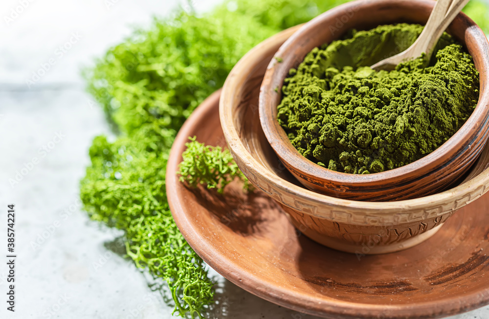 Green powder chlorella, spirulina on gray concrete background. Concept dieting, detox, healthy superfood, which contains protein. Green powder chlorella, spirulina on gray concrete background. Concept dieting, detox, healthy superfood, which contains protein.