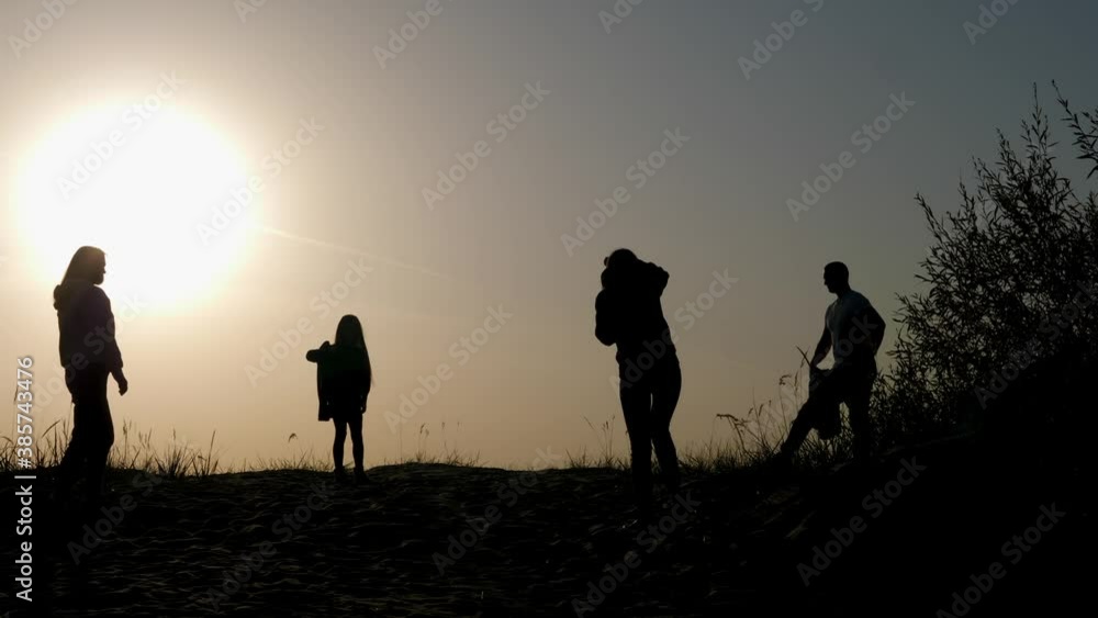 family of three photographed at sunset by the sea in silhouette family of three photographed at sunset by the sea in silhouette