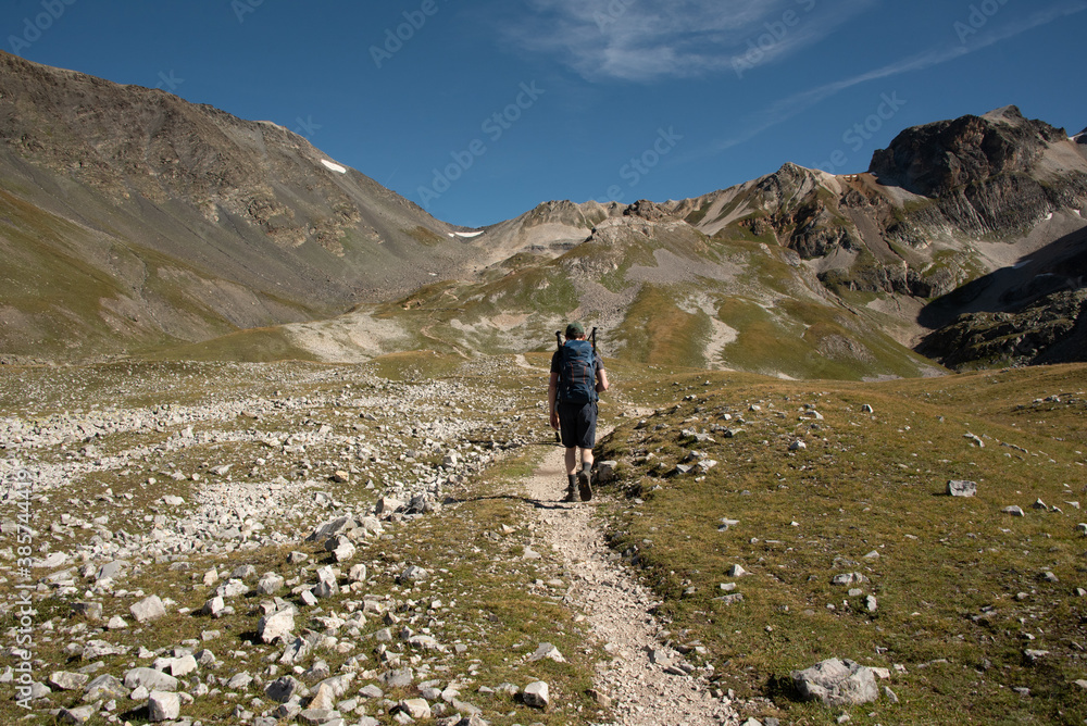 a hiker walks alone in the mountains ready to conquer the world that is opening up to him