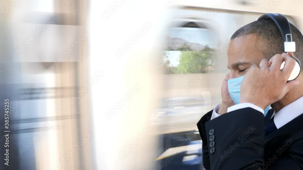 Businessman in a suit waits for a train while wearing a face mask to protect from getting sick Businessman in a suit waits for a train while wearing a face mask to protect from getting sick