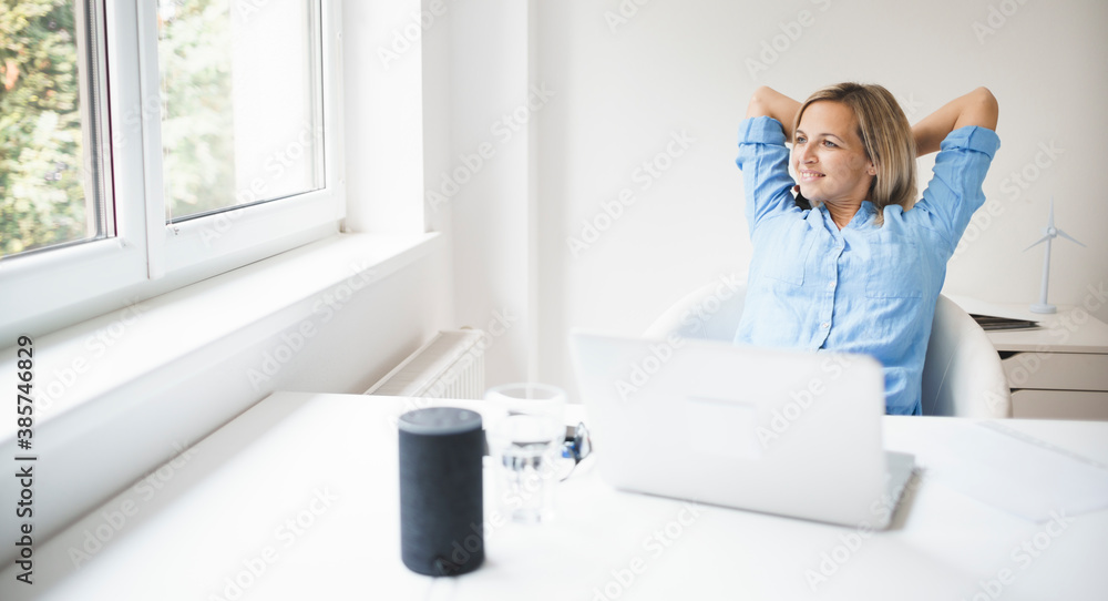 beautiful business woman is relaxing in her homeoffice behind her notebook during corona time