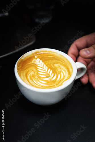 Cup of coffee. Latte art made by barista focus in milk and coffee. Vintage color