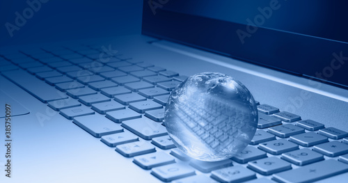 Fototapeta Naklejka Na Ścianę i Meble -  Glass globe on laptop keyboard 
