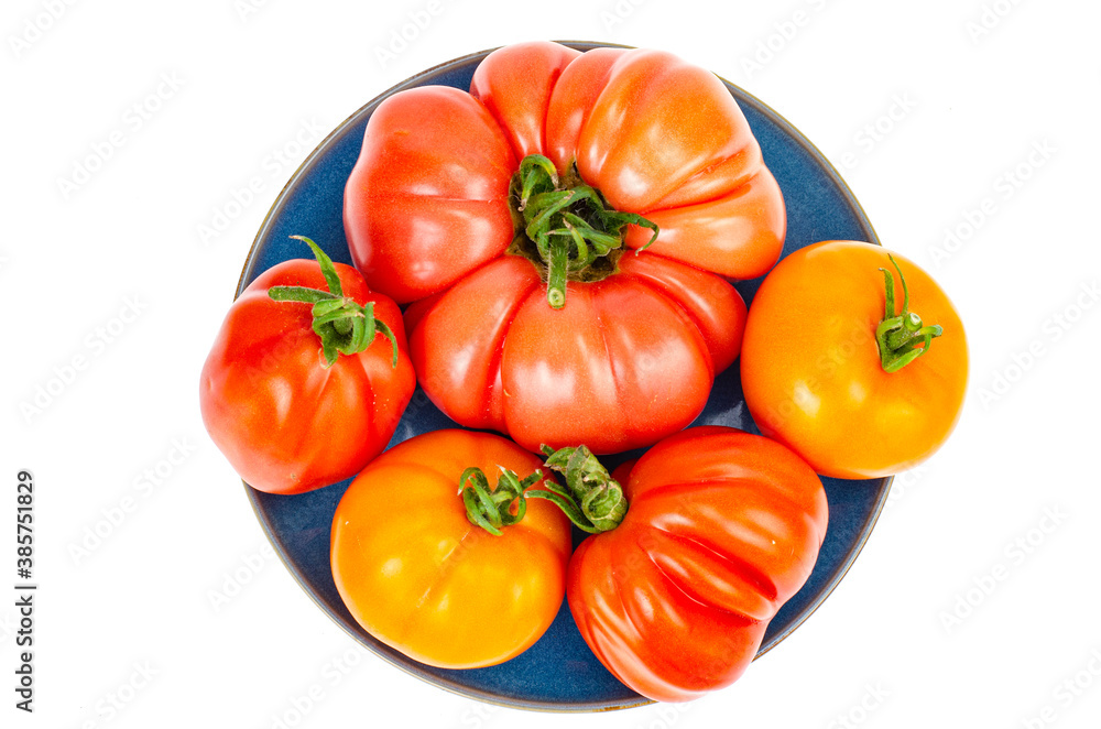 Bright colorful tomatoes on plate isolated on white background. Bright colorful tomatoes on plate isolated on white background.