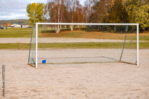 Soccer goal on the gravel field with trees in the back photo