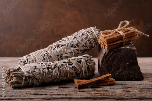 White sage smudge and sticks palo santo on the wooden background.