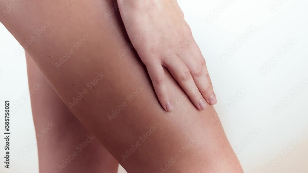 Woman applying moisturizer cream or body lotion on her legs