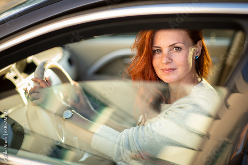 Pretty, young woman driving a car -Invitation to travel. Car rental or vacation.
