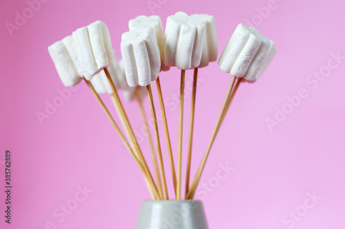 bouquet of marshmallows in a vase on a pink background.