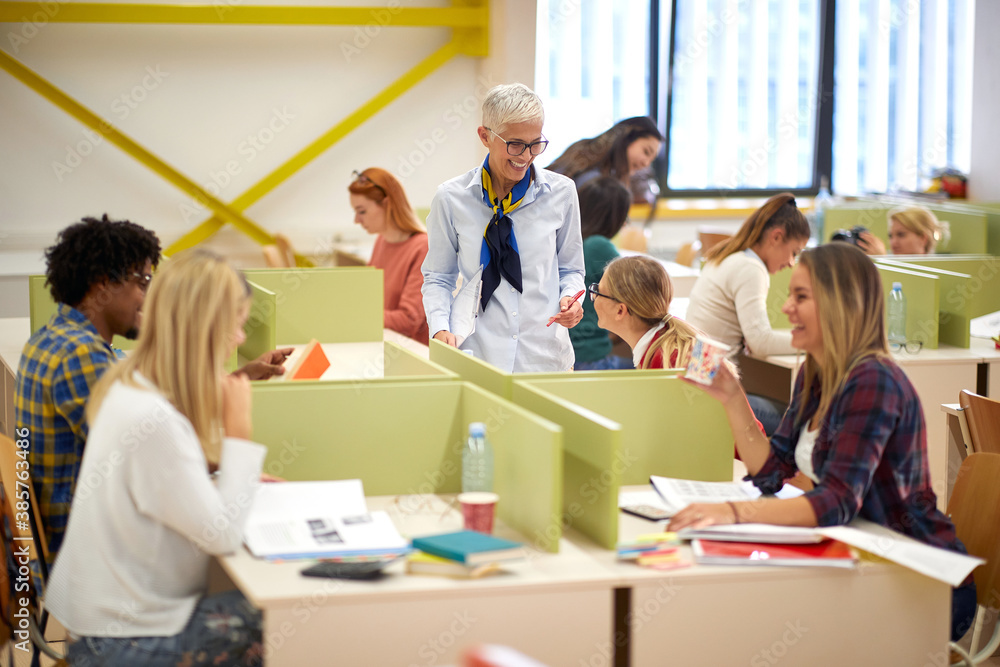 Female professor discussing a lesson with students at a lecture Female professor discussing a lesson with students at a lecture
