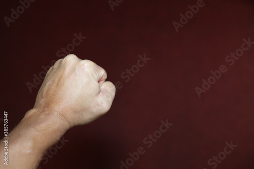 Verschiedene emotionale Zeichen mit der linken Männerhand vor einem dunkelroten Hintergrund, die etwa Angst, Wut, oder Freundschaft symbolisieren. photo