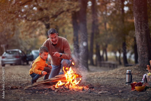 Grandfather and grandson enjoying a campfire in the forest