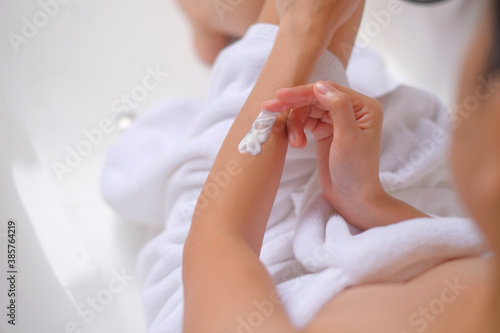 Woman applying cream lotion on hand with white background  Beauty concept. Top view